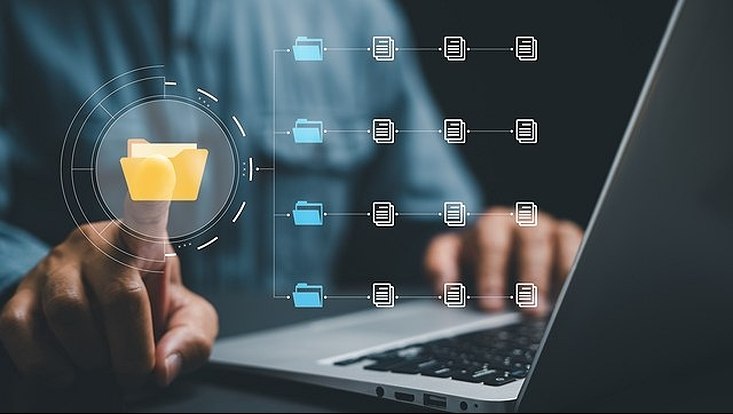 Person at a laptop typing into a digital file folder