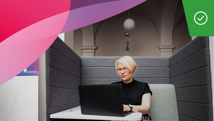 Person sitting in front of laptop in individual workspace