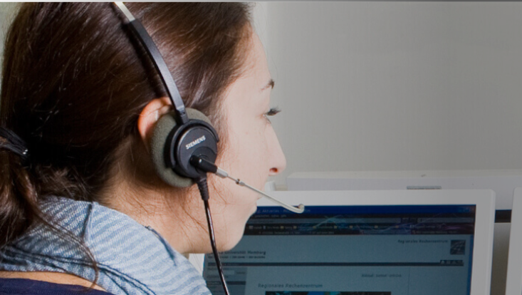 Woman with headset sitting at a PC